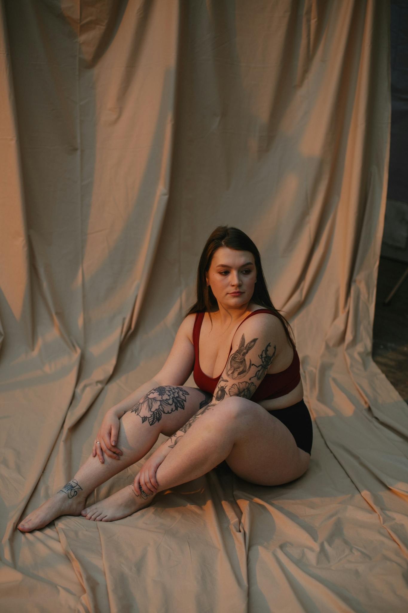 Woman in Red Brassiere Sitting on Brown Blanket